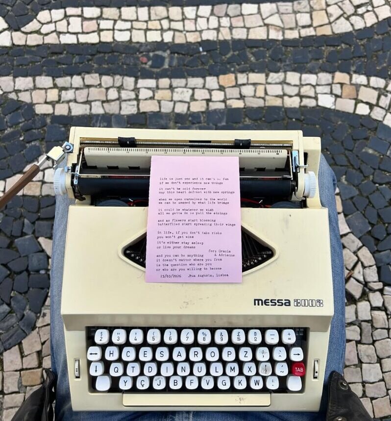 Máquina de escrever com um poema acabado de escrever, sobre a calçada portuguesa da Rua Augusta